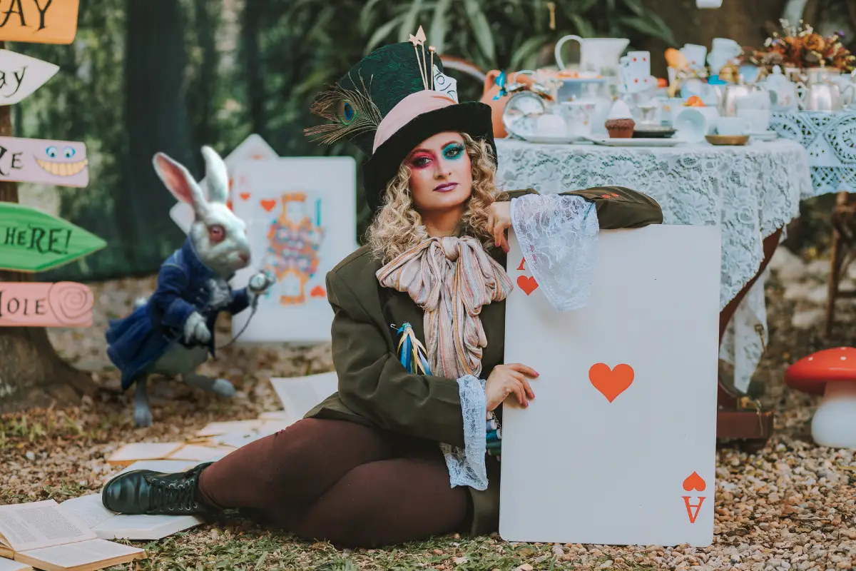 An actress holding up a huge ace of spades with a rabbit in the background.