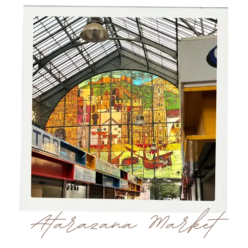 The interior view of the stained glass wall of Atarazanas market in Malaga depicting boats, horses and fields.