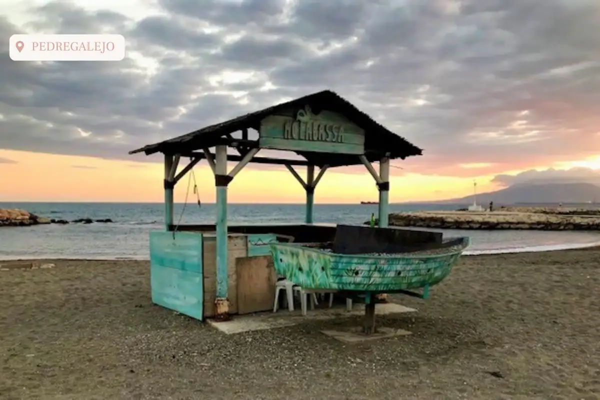 A hut on the beach at Playa Pedregalejo used to cook sardines with the ocean behind it.