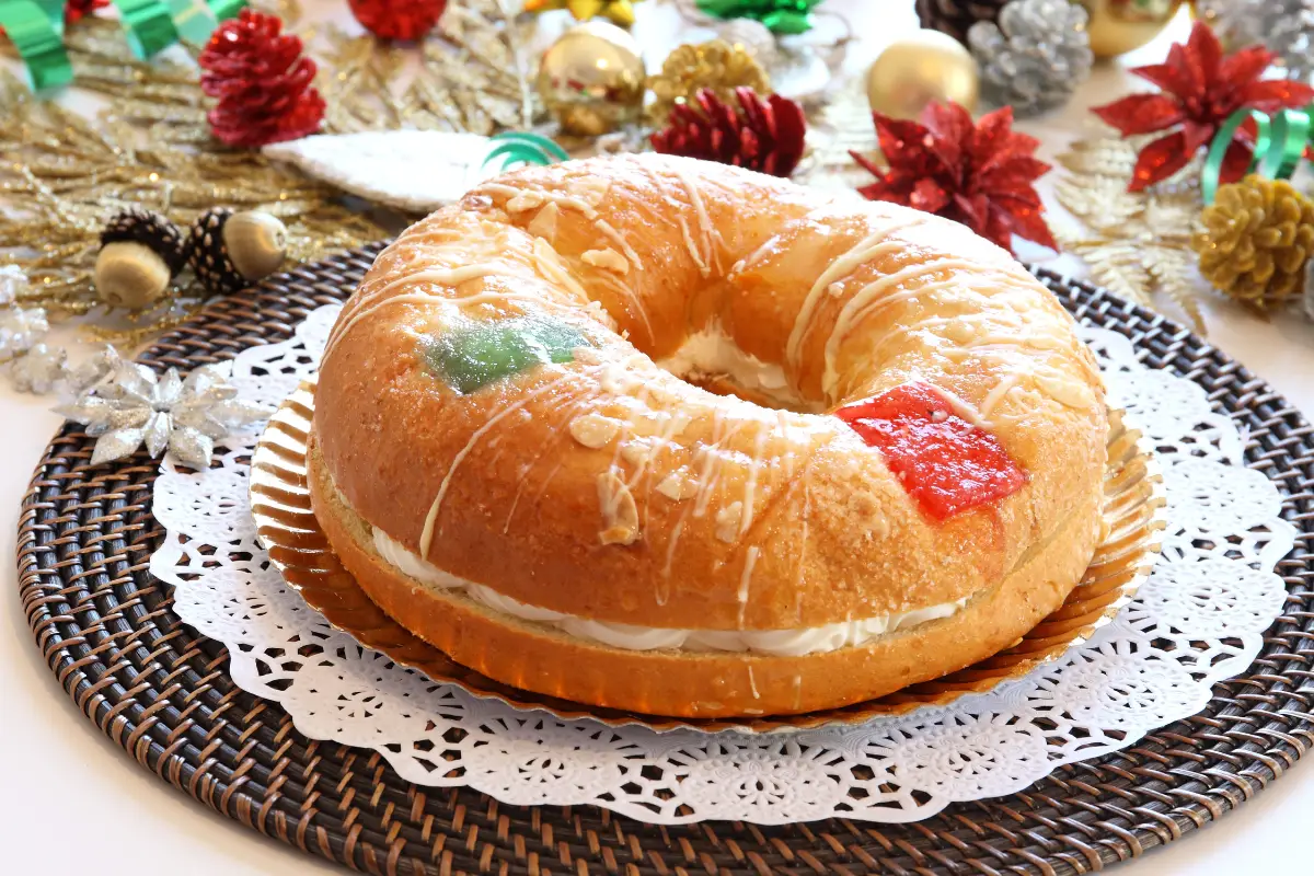 A roscon de reyes Christmas cake on a plate with acorns around it.
